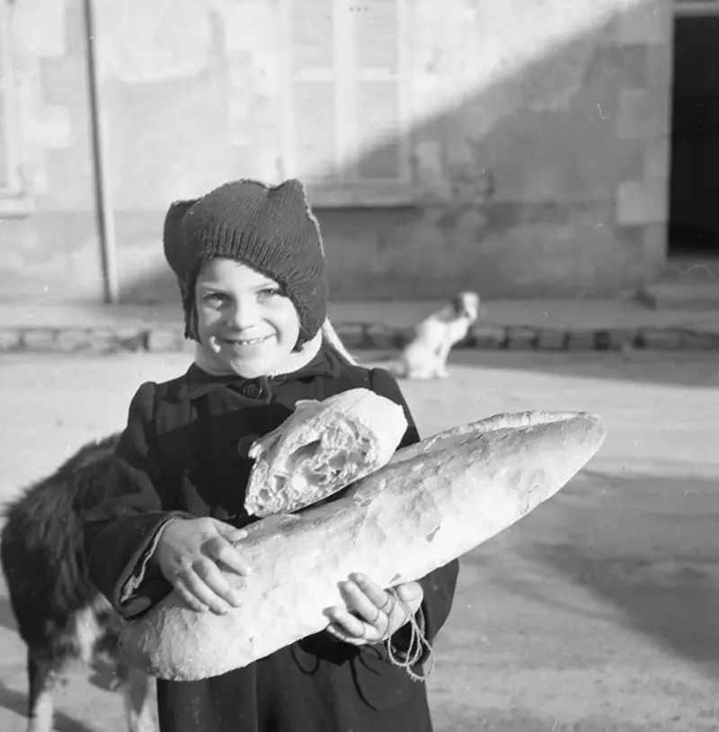 Niño portando barra de pan.