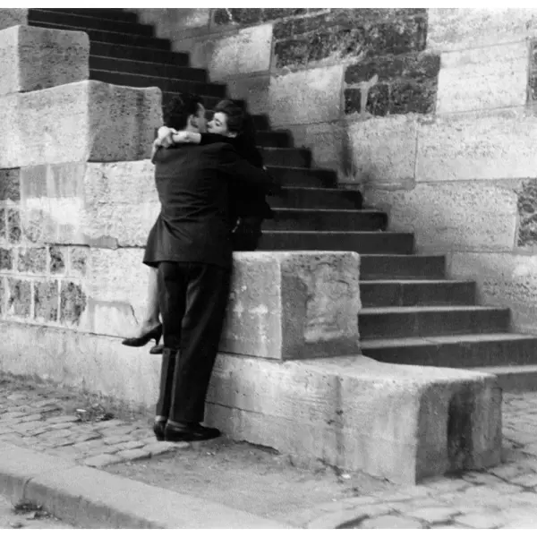 A couple embraces on a quiet stone stairway 