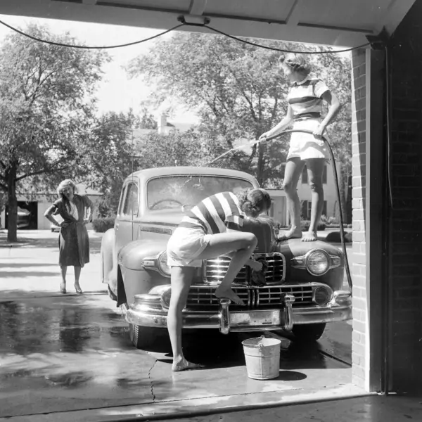 Two daughters wash the family car 