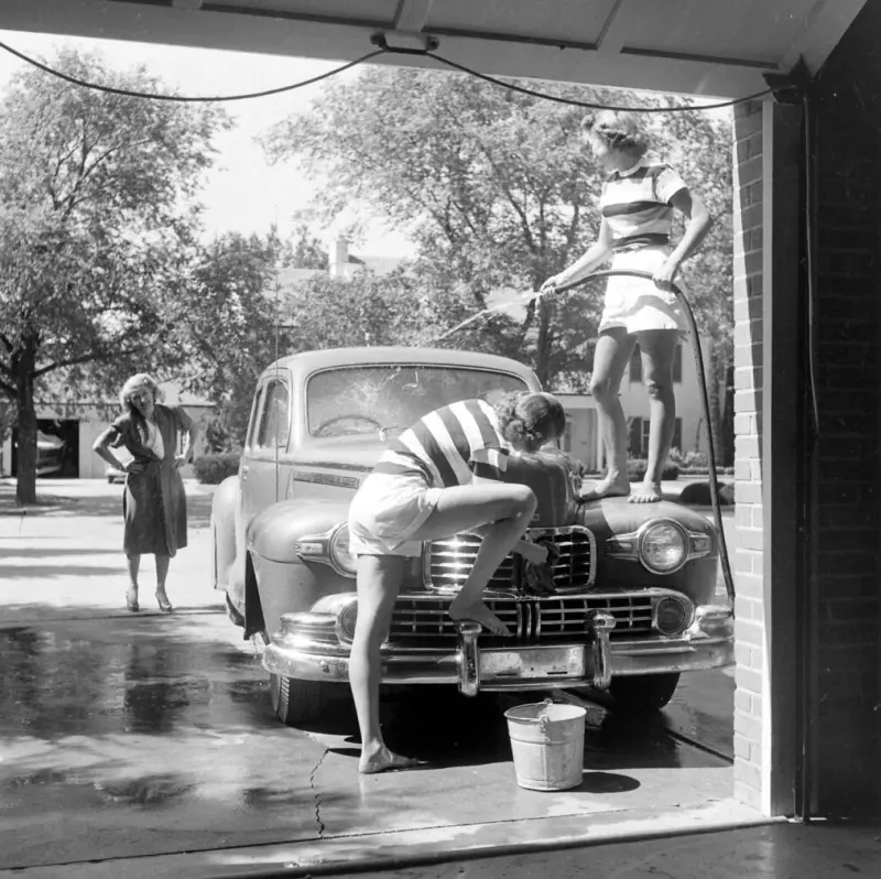 Two daughters wash the family car 