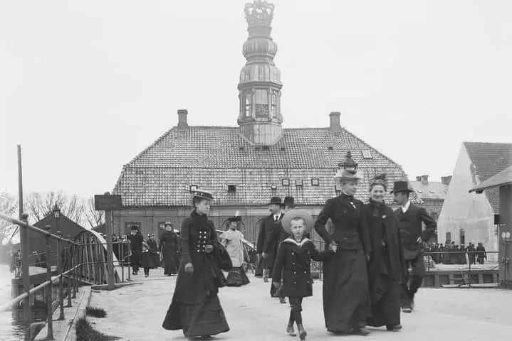 A group of well dressed people out for a stroll.