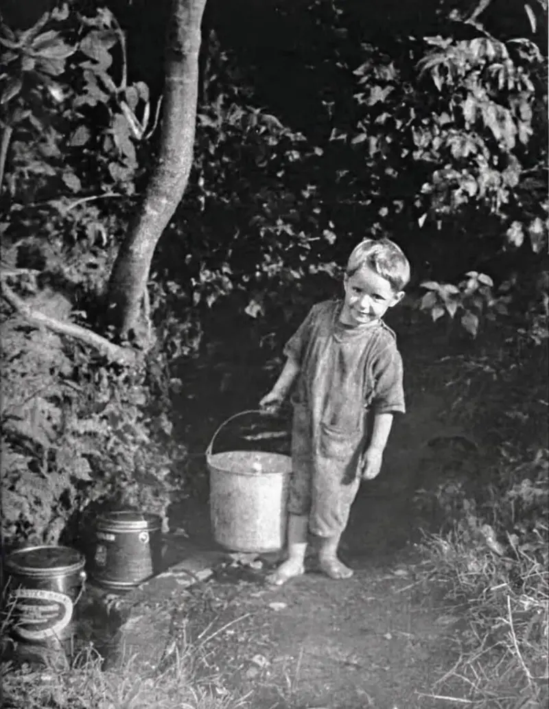 A mountain boy fetches water from a spring