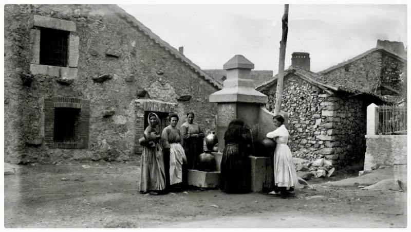 Mujeres cogiendo agua en la fuente.