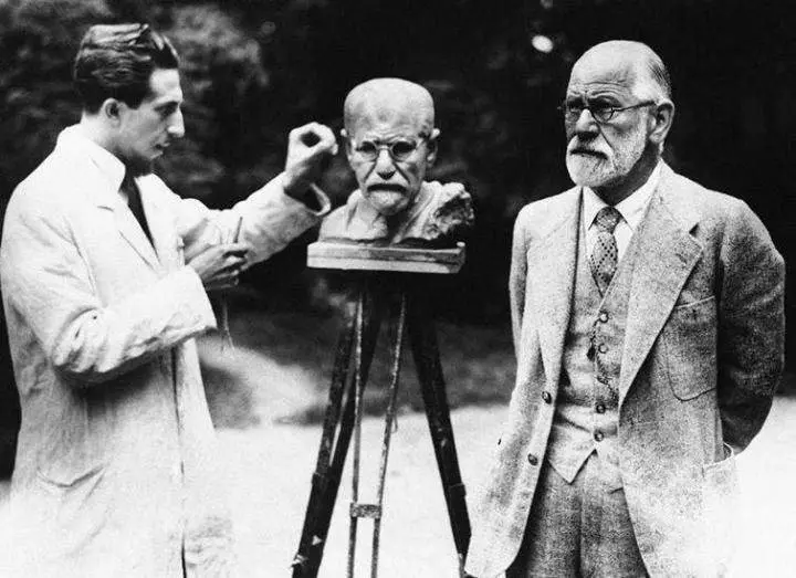 Sigmund Freud poses while sculptor Oscar Nemov makes his own bust