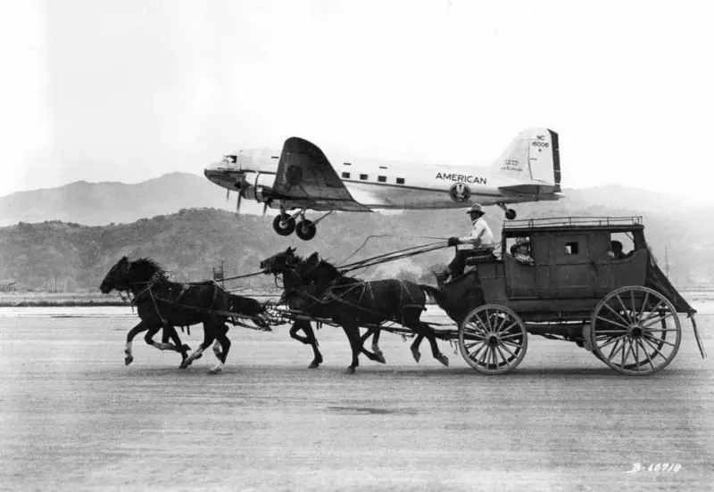 An American Airlines DC-3 Plane Flying Past a Stagecoach