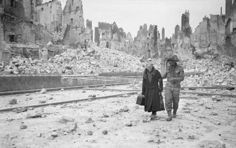 A British soldier escorts an elderly lady