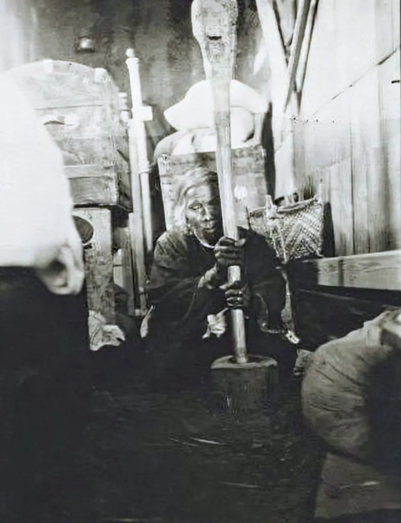A woman from Fort Berthold grinds corn