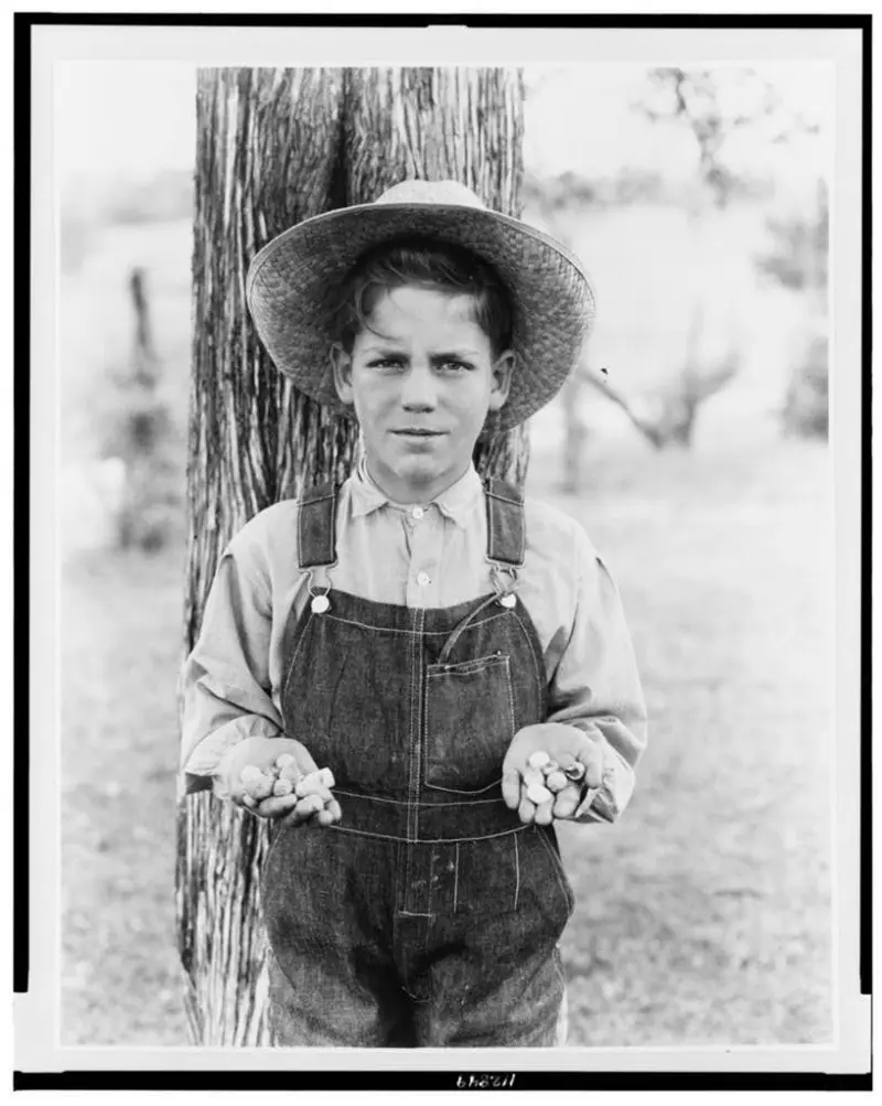 boy holding a bunch of found confederate bullets
