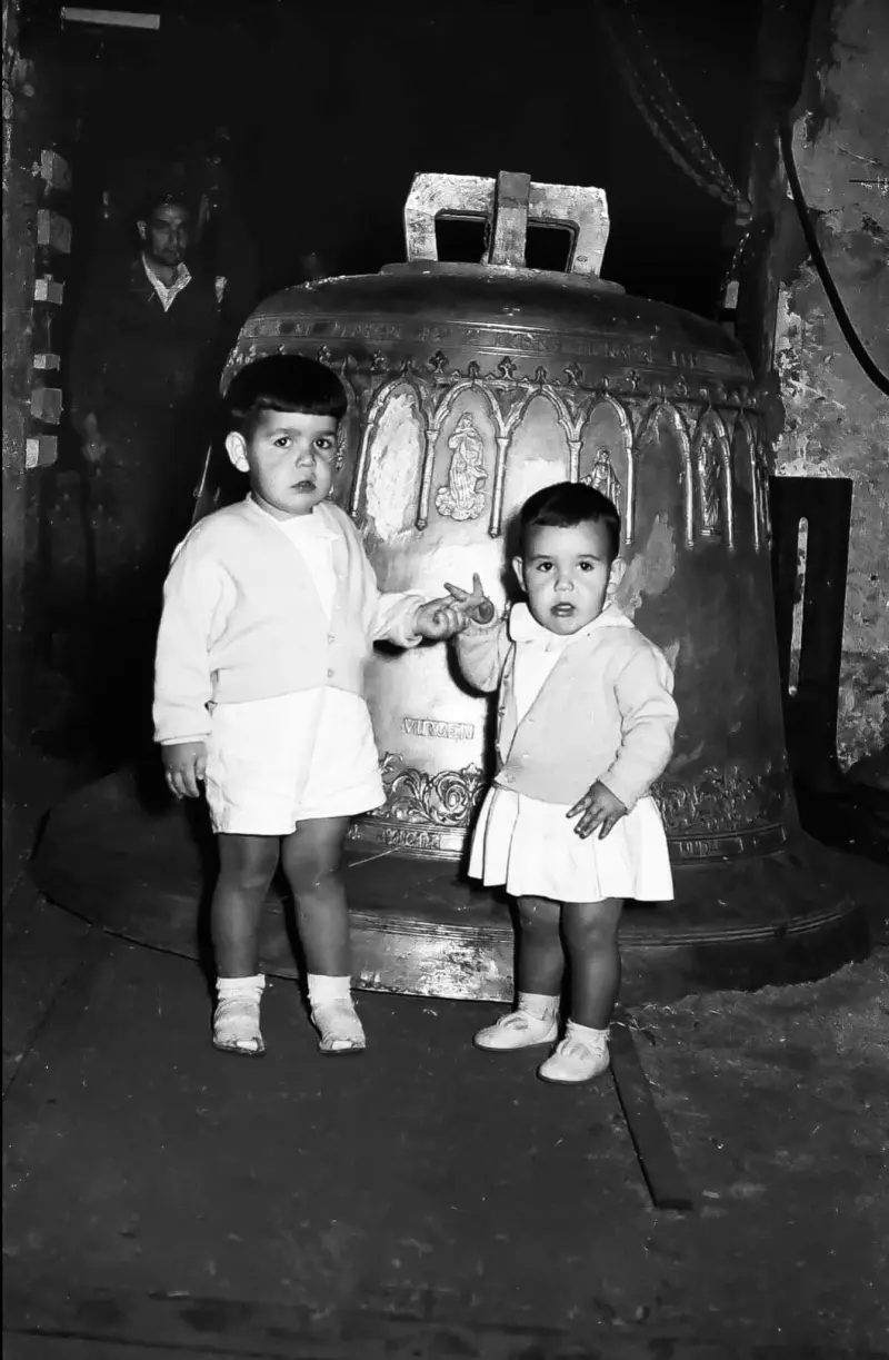Niños junto a una campana
