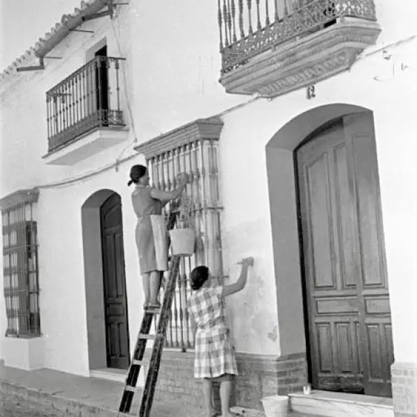 Mujeres enjalbegando una fachada.