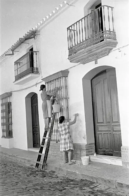 Mujeres enjalbegando una fachada.