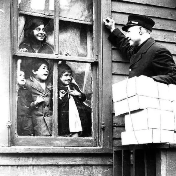 Children smile out a window