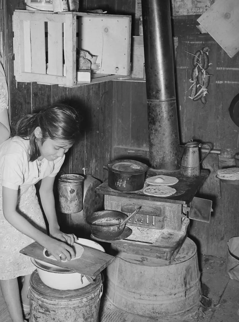 A young girl makes tortillas