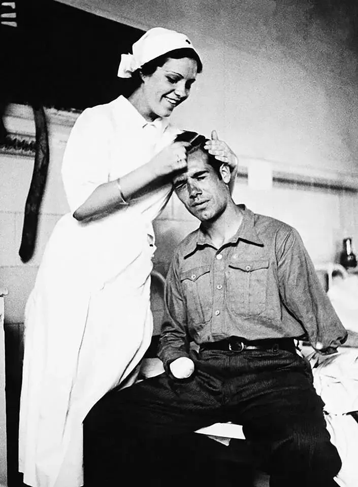 Una enfermera peina a un miliciano