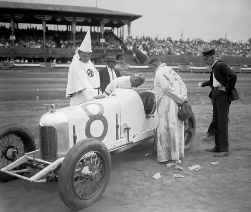 Ku Klux Klan racing drivers checking the car
