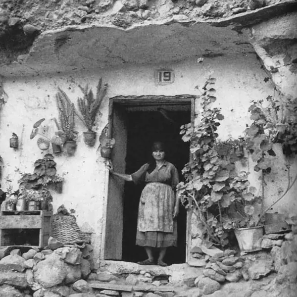 Mujer en la entrada de una casa-cueva.