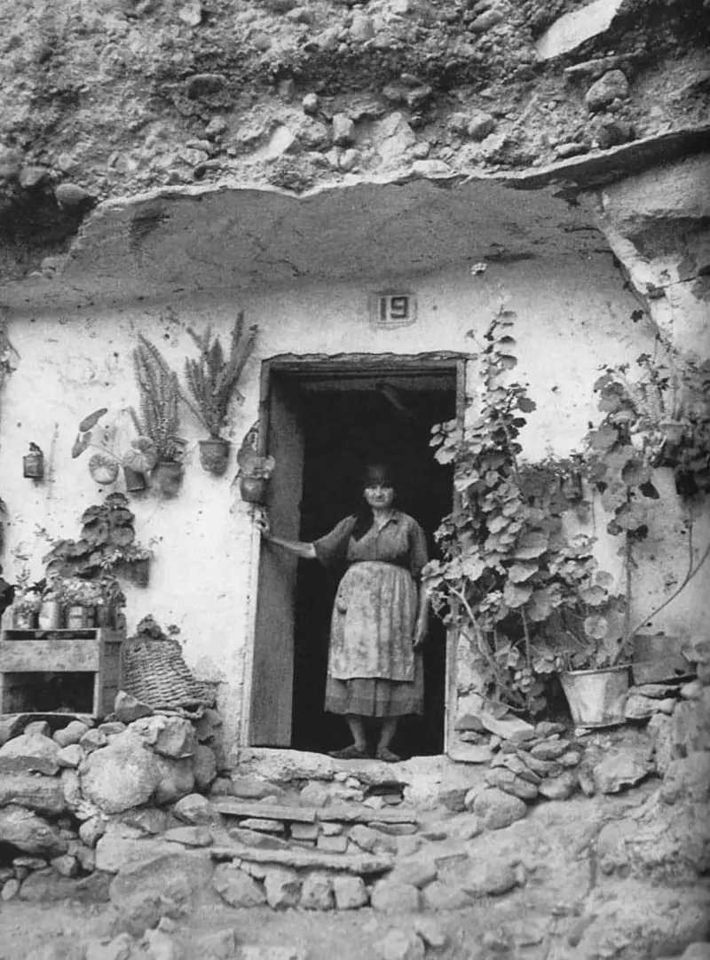 Mujer en la entrada de una casa-cueva.