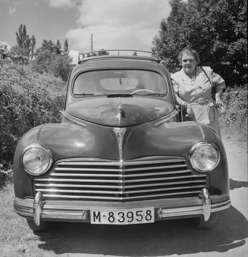Mujer apoyada en un coche