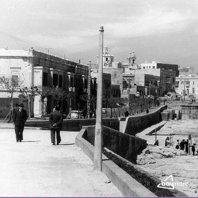 Men in suits stroll along promenade
