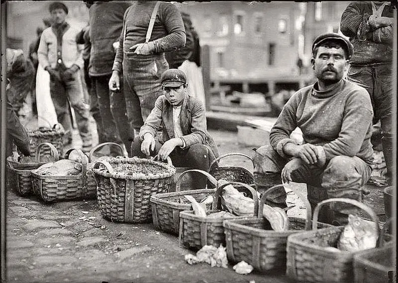 Boy selling fish from a basket in Boston street market