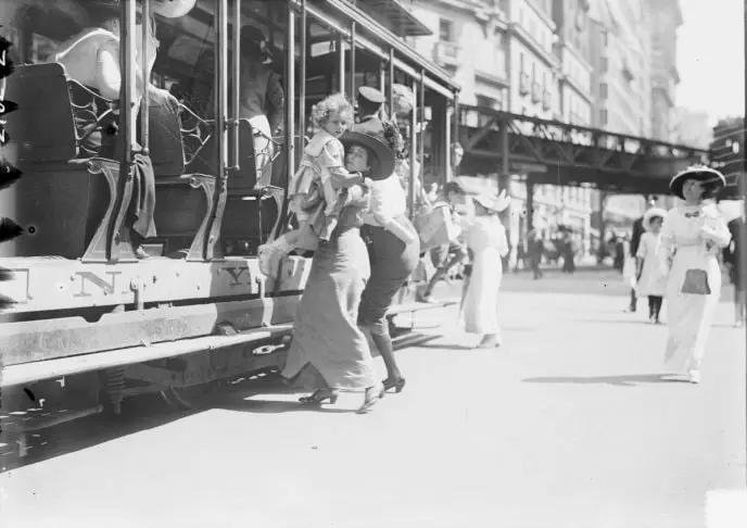 Mother helping child off a tram
