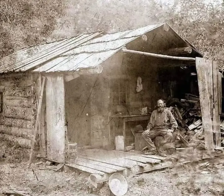 A man on the porch of his cabin