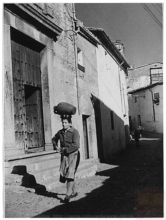 MUJER TRANSPORTANDO AGUA