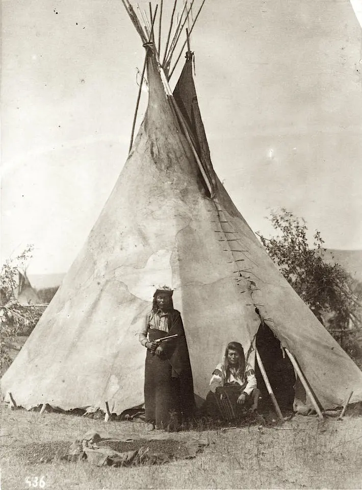 Nez Perce men by teepee. 