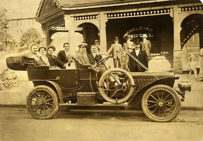 A group in a Stevens-Duryea in front of the Charles Kirst Hotel