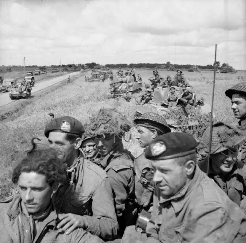 British infantry aboard Sherman tanks wait for the order to advance