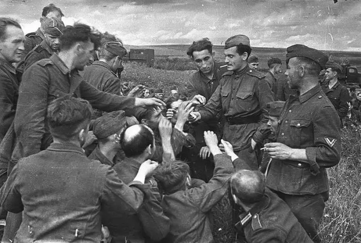 Soviet Soldier Giving Cigarettes to German Prisoners of War