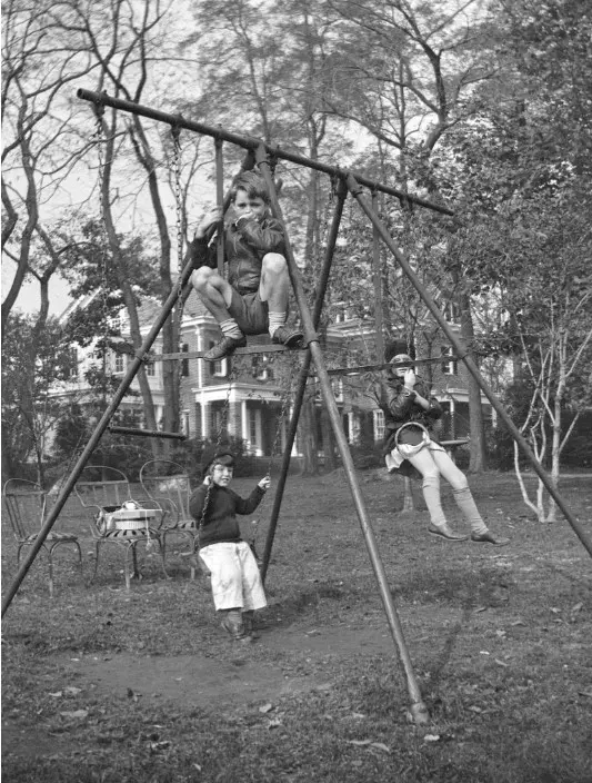 Robert F. Kennedy,  Edward M. and Jean Kennedy play  on a swing set 