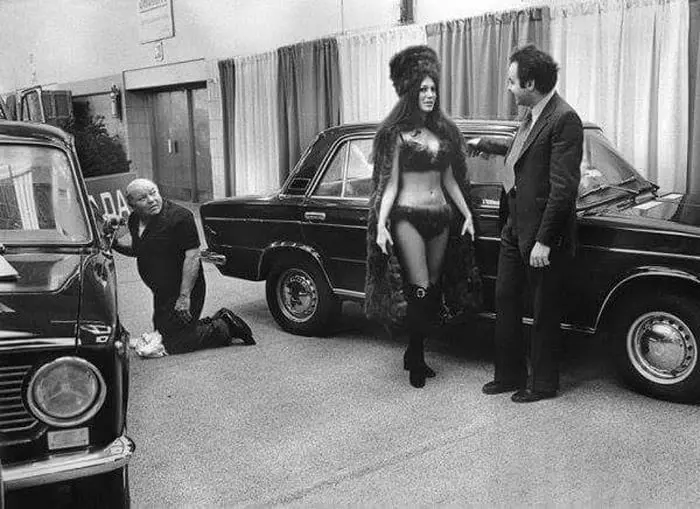 A model in a sable bikini presents a LADA car