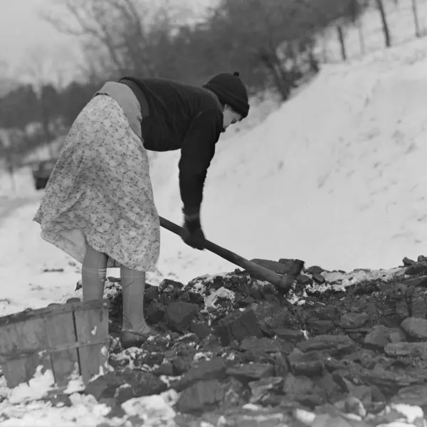 A woman gathering coal 