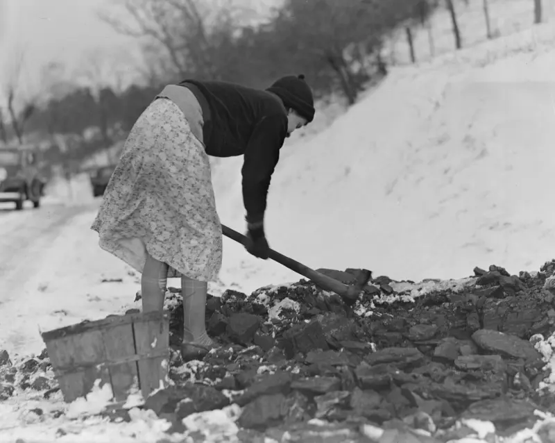 A woman gathering coal 