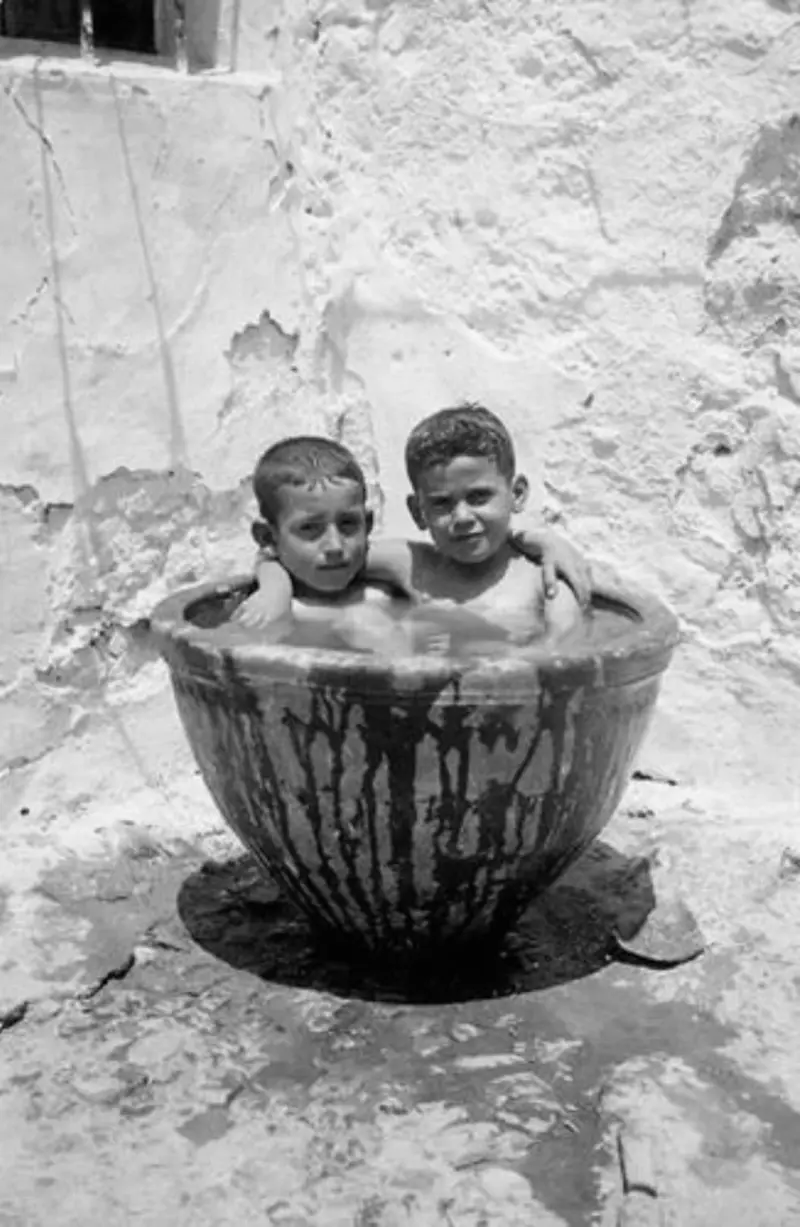 Dos niños bañándose al sol.