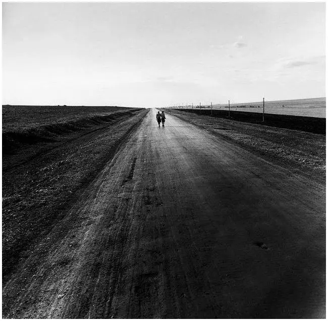 Two women walking down a road