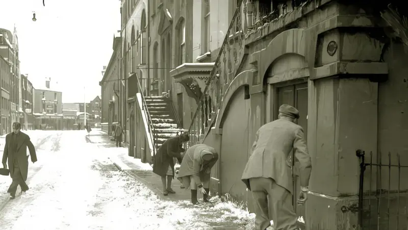 People clearing the snow from the pavement on Academy Street
