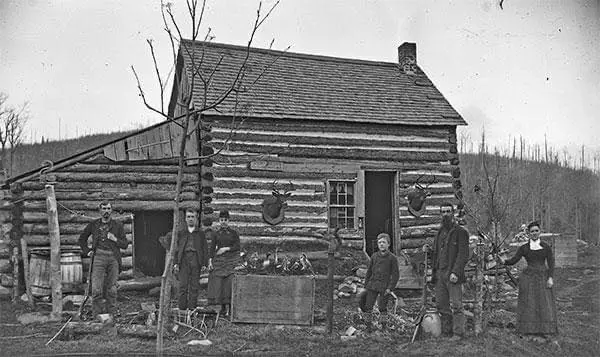 A family at their log cabin in the Adirondack Mountains near Johnsburg