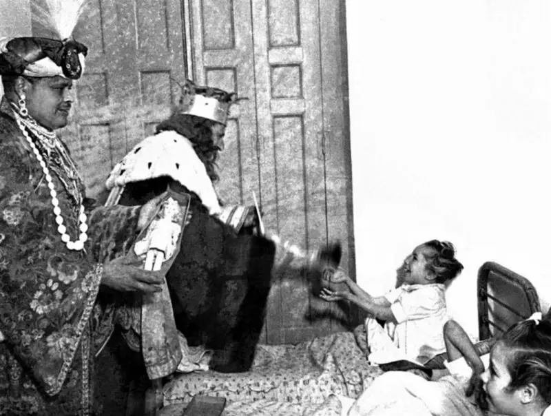 Reyes Magos repartiendo regalos a niños acogidos en uno de los denominados "Hogares del Auxilio Social".