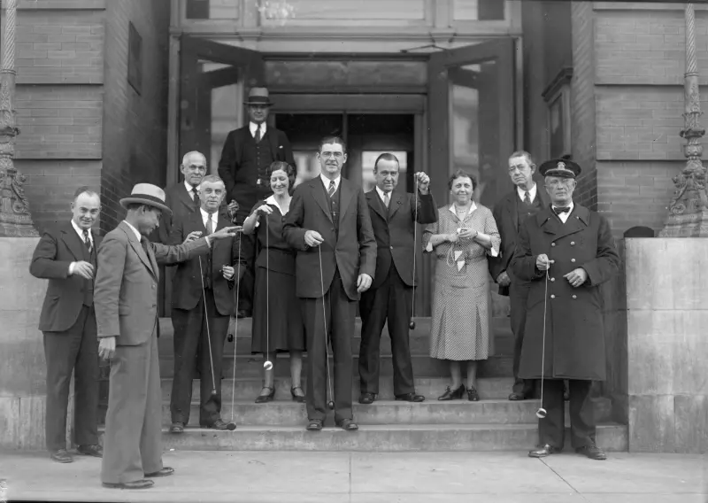 Group of city officials holding Yo-Yos on the steps of City Hall