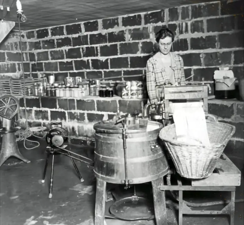 A woman uses an antique Maytag washing machine.