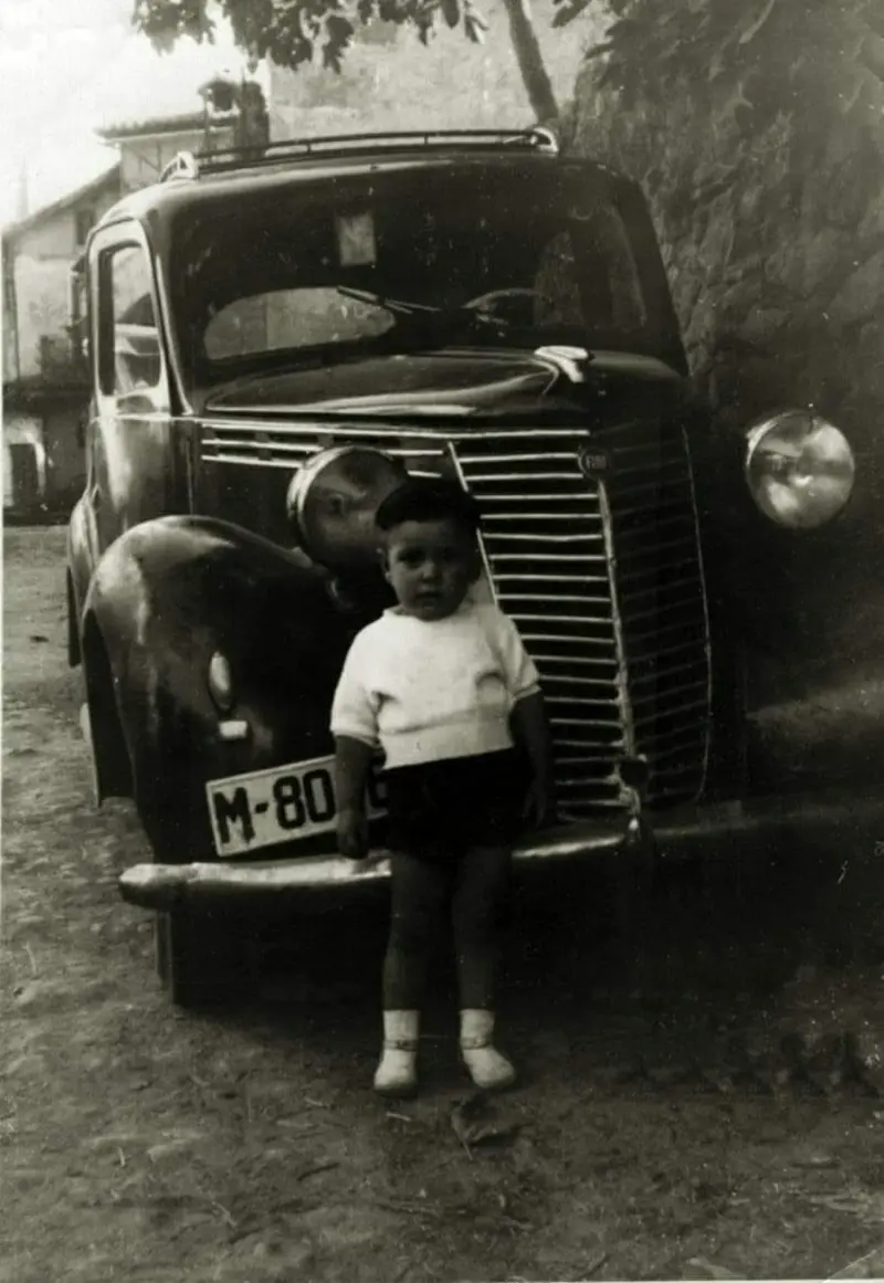 Niño junto a un coche. 