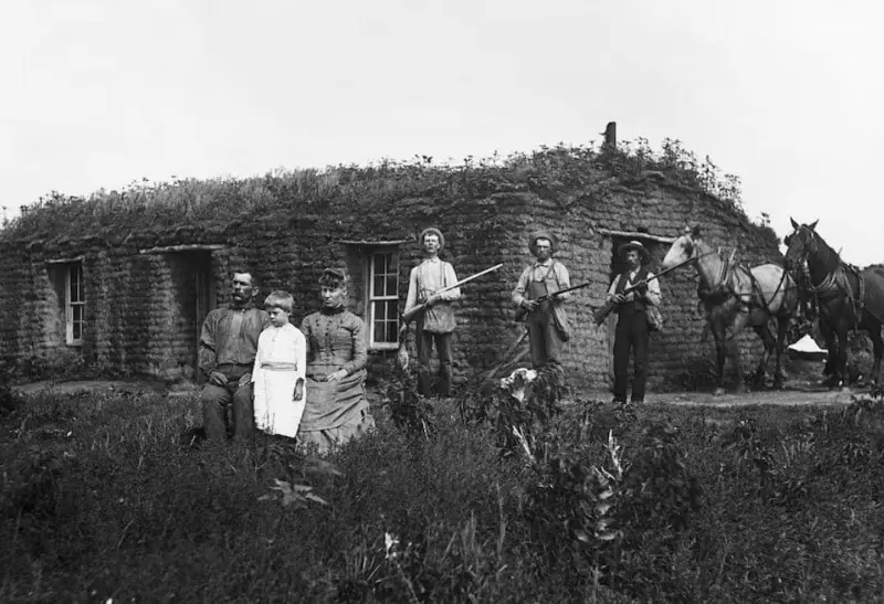 A family in front of their sod house