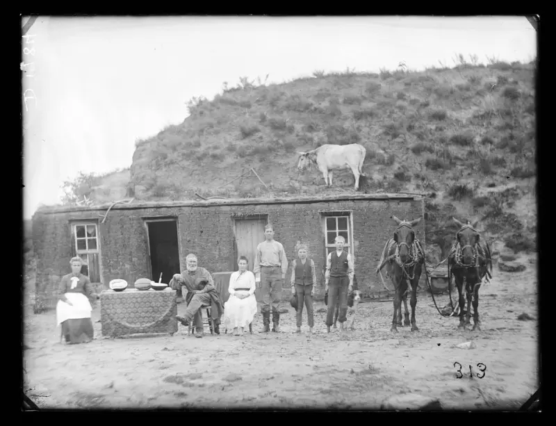 Family settled in with the sod house they made.