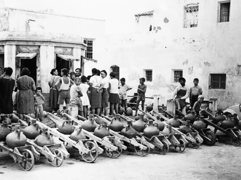 Vecinos esperan su turno para recoger agua.