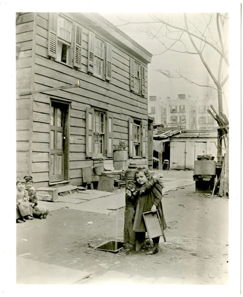 Unidentified girl at the water pump at the rear of 65 E. 87th Street, north side between Madison and Park