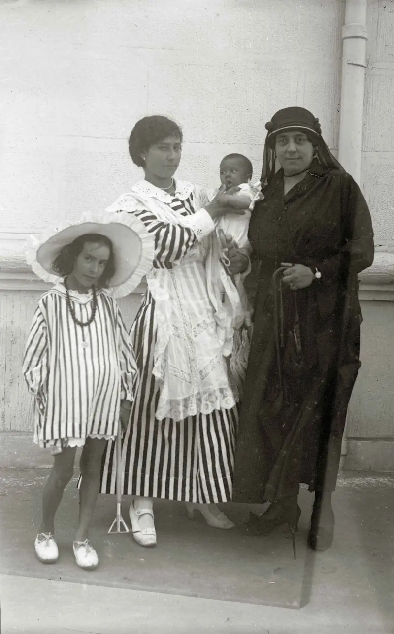 Aya y mujer vestida de negro con dos niños