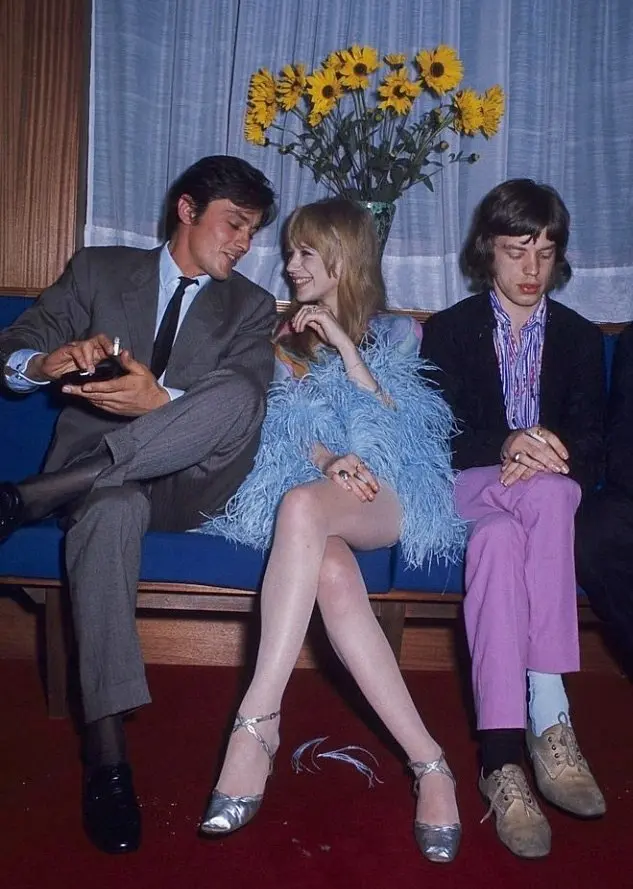 Mick Jagger, Alain Delon, and Marianne Faithfull at a restaurant in Paris