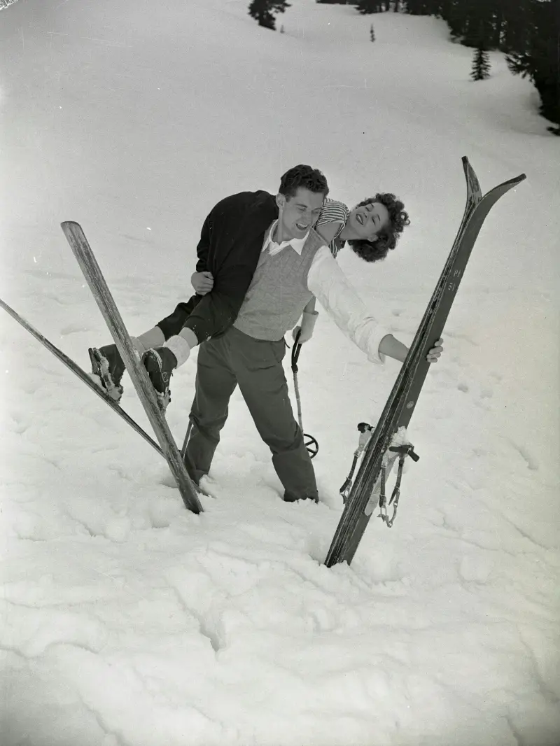 A man and woman play in the snow